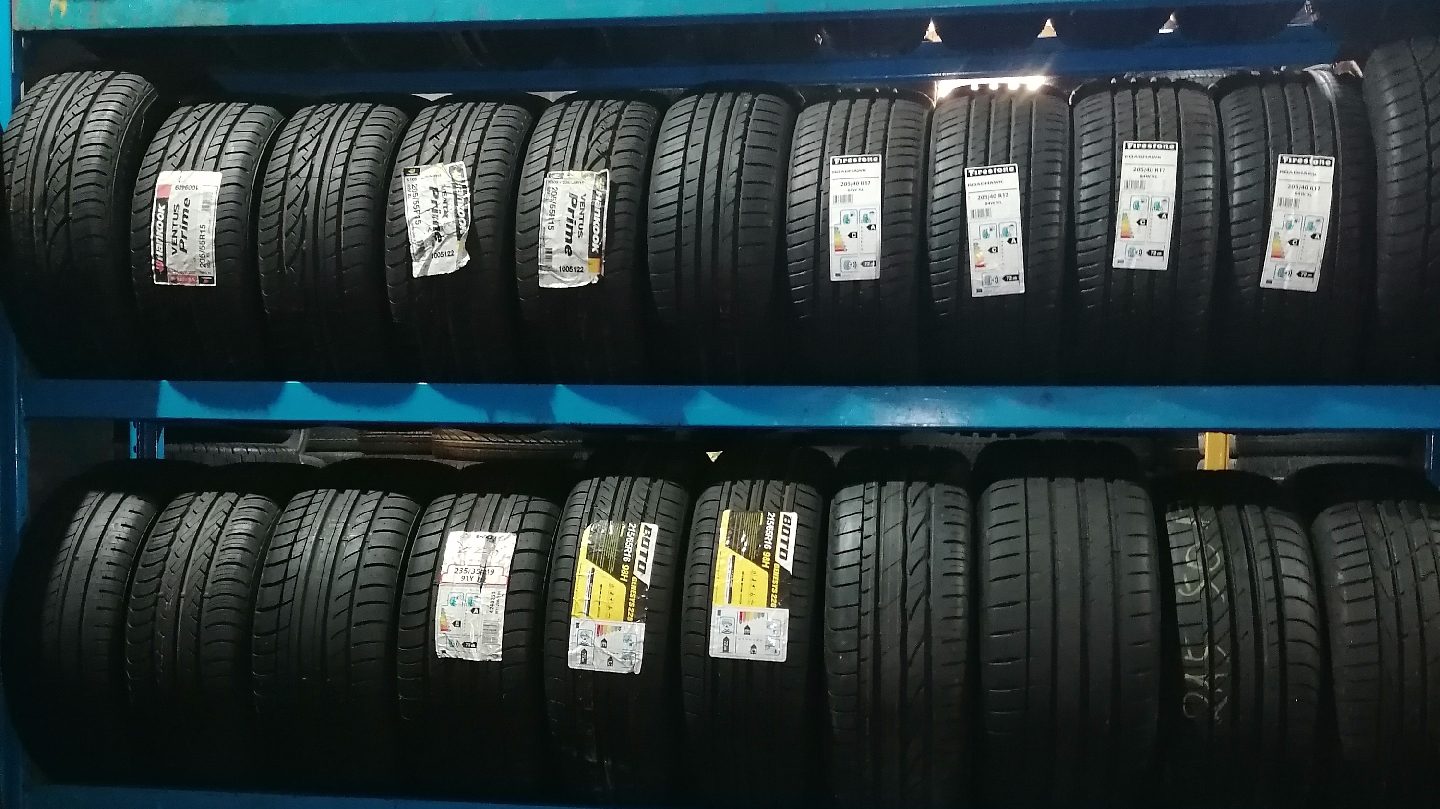 Rows of brand new labelled tyres on blue racking